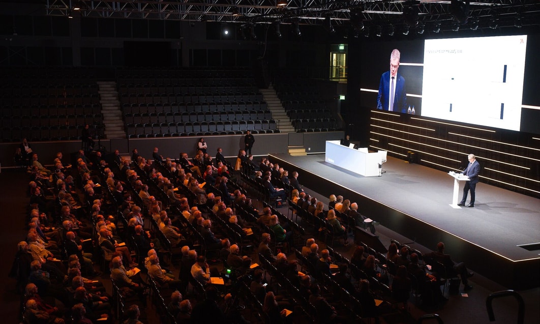 en grupp människor som sitter i stolar i ett stort auditorium