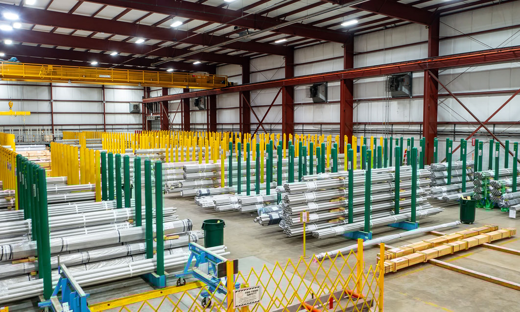a warehouse with persony stacks of metal pipes