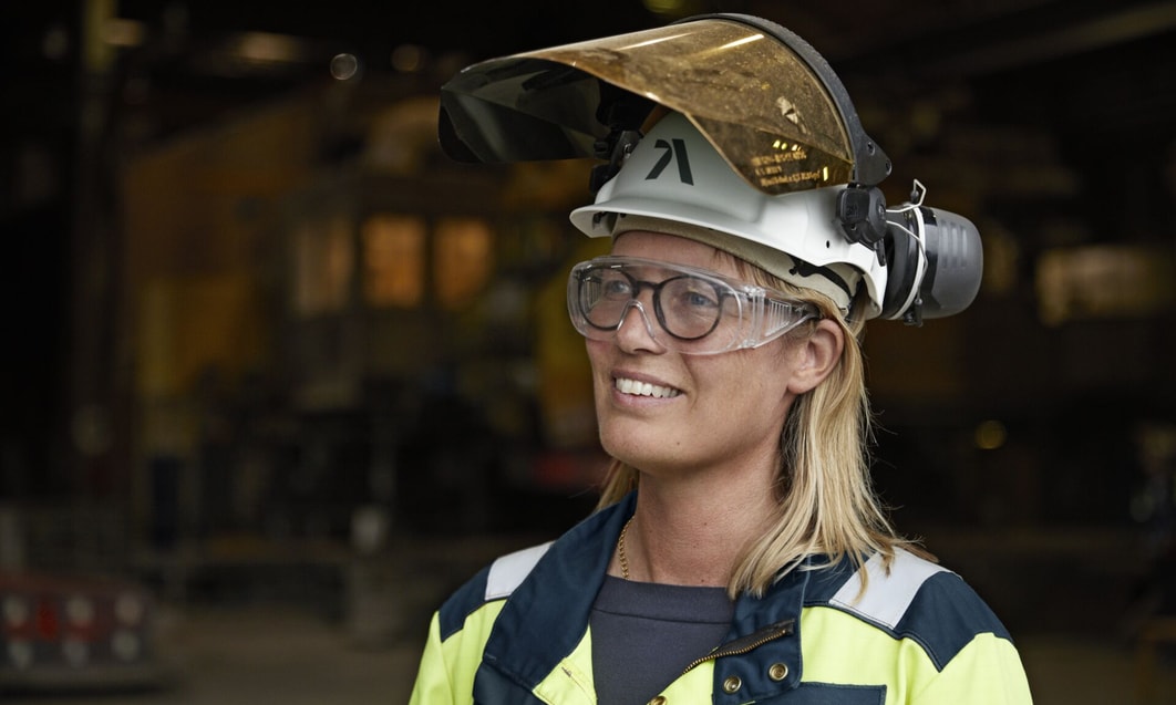 en person som bär skyddshjälm och skyddsglasögon