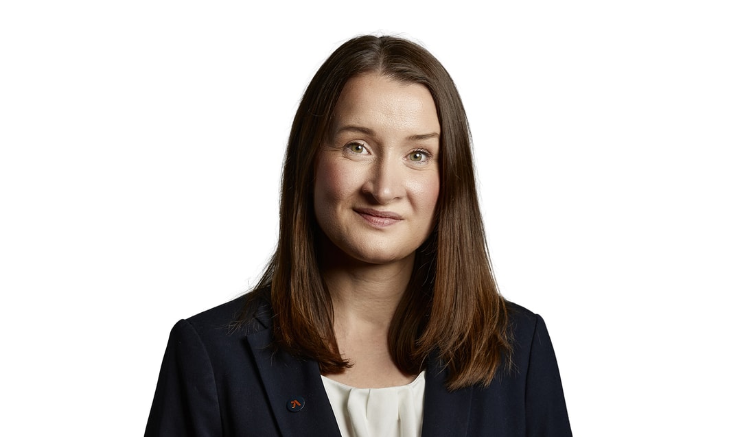 en person med brunt hår som bär kostym