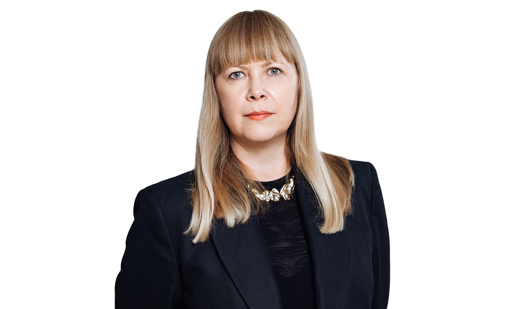 en person med blont hår som bär en svart kostym