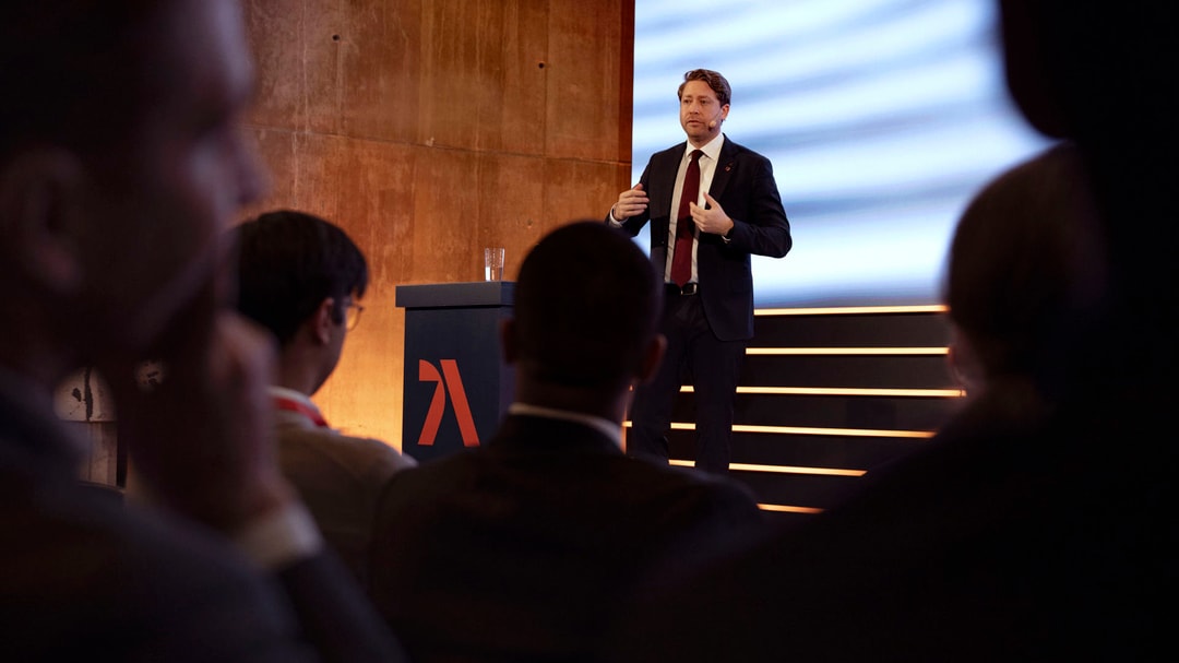 a person standing on a stage giving a presentation
