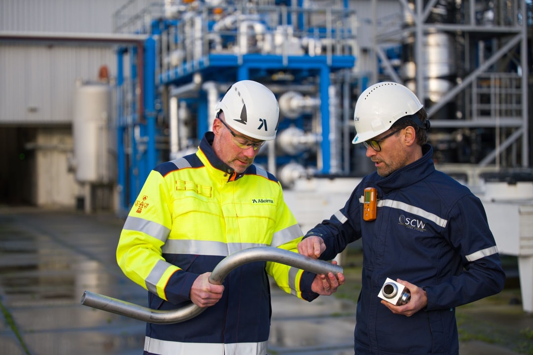 a person in a hard hat holding a pipe