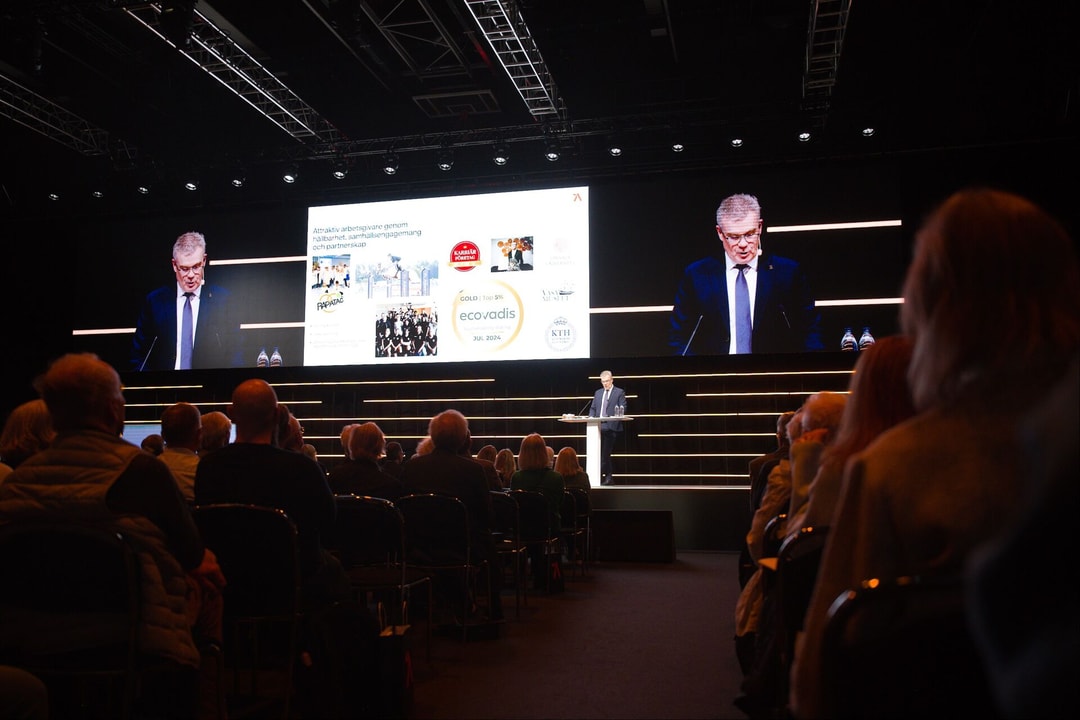 a person standing in front of a stage with a large screen