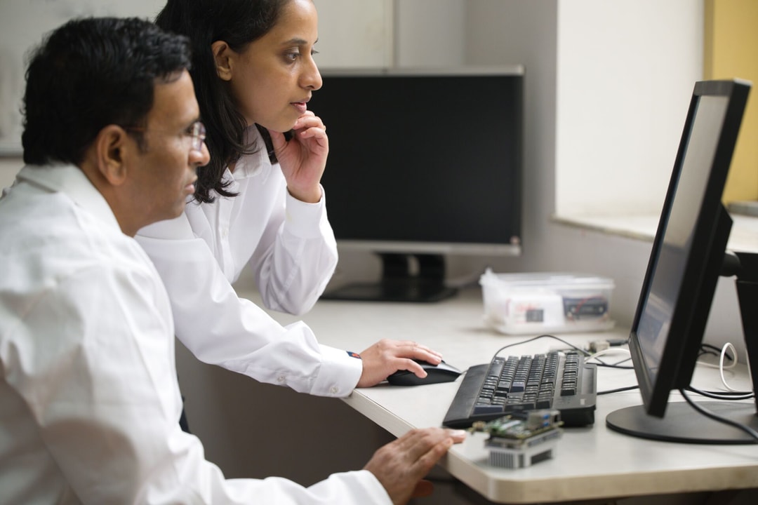 en person och en person som tittar på en dator