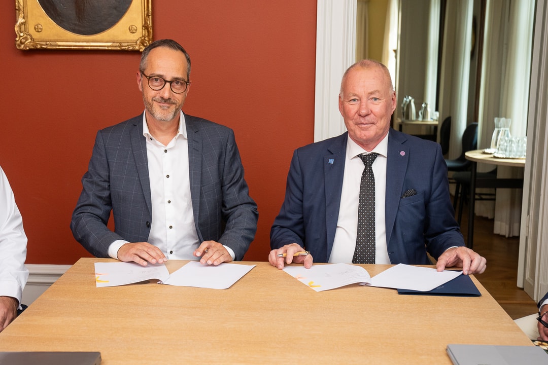 two men sitting at a table with papers