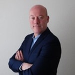 en person i kostym med armarna i kors