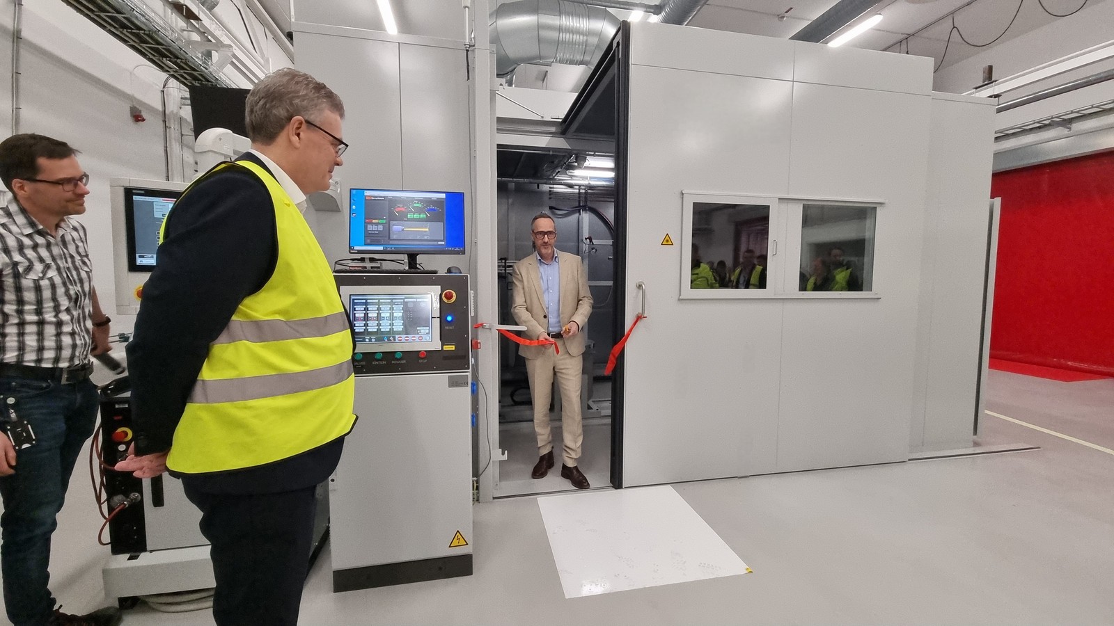 黄色いベストを着た人と部屋に立つ人