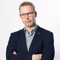 en person i kostym med armarna i kors