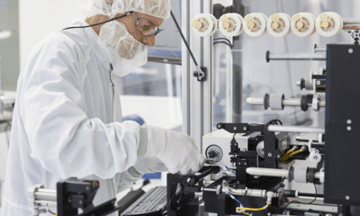 en person i vit kostym som arbetar på en maskin