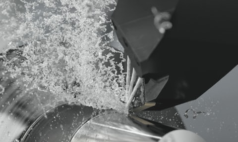 water spraying water on a metal piece