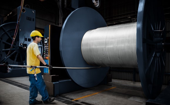 en person som bär skyddshjälm och håller i en kabel