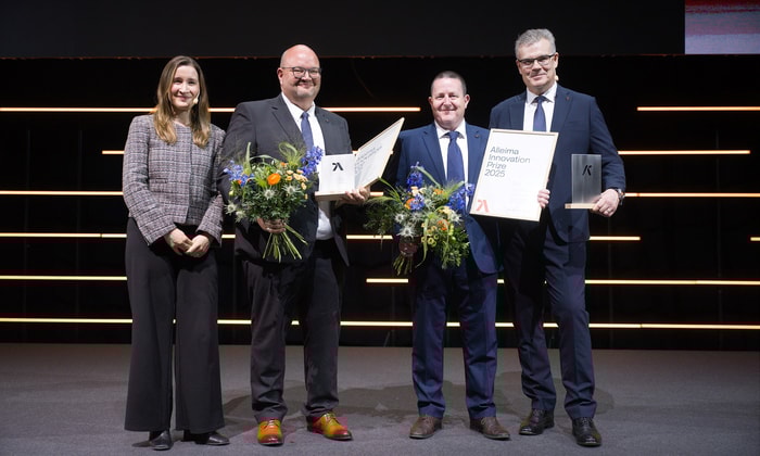 a group of people holding flowers and awards