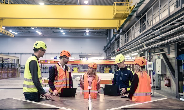 a group of people in orange vests and helmets