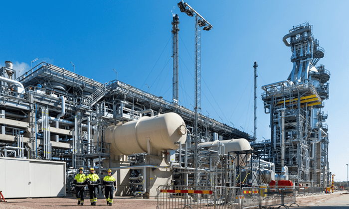 en grupp människor som står framför en fabrik