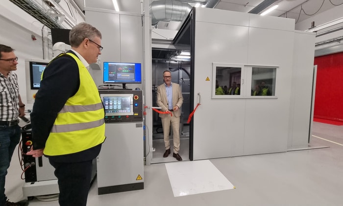a person standing in a room with a person in a yellow vest