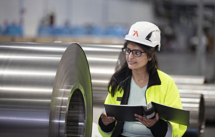 a person wearing a hard hat and holding a clipboard